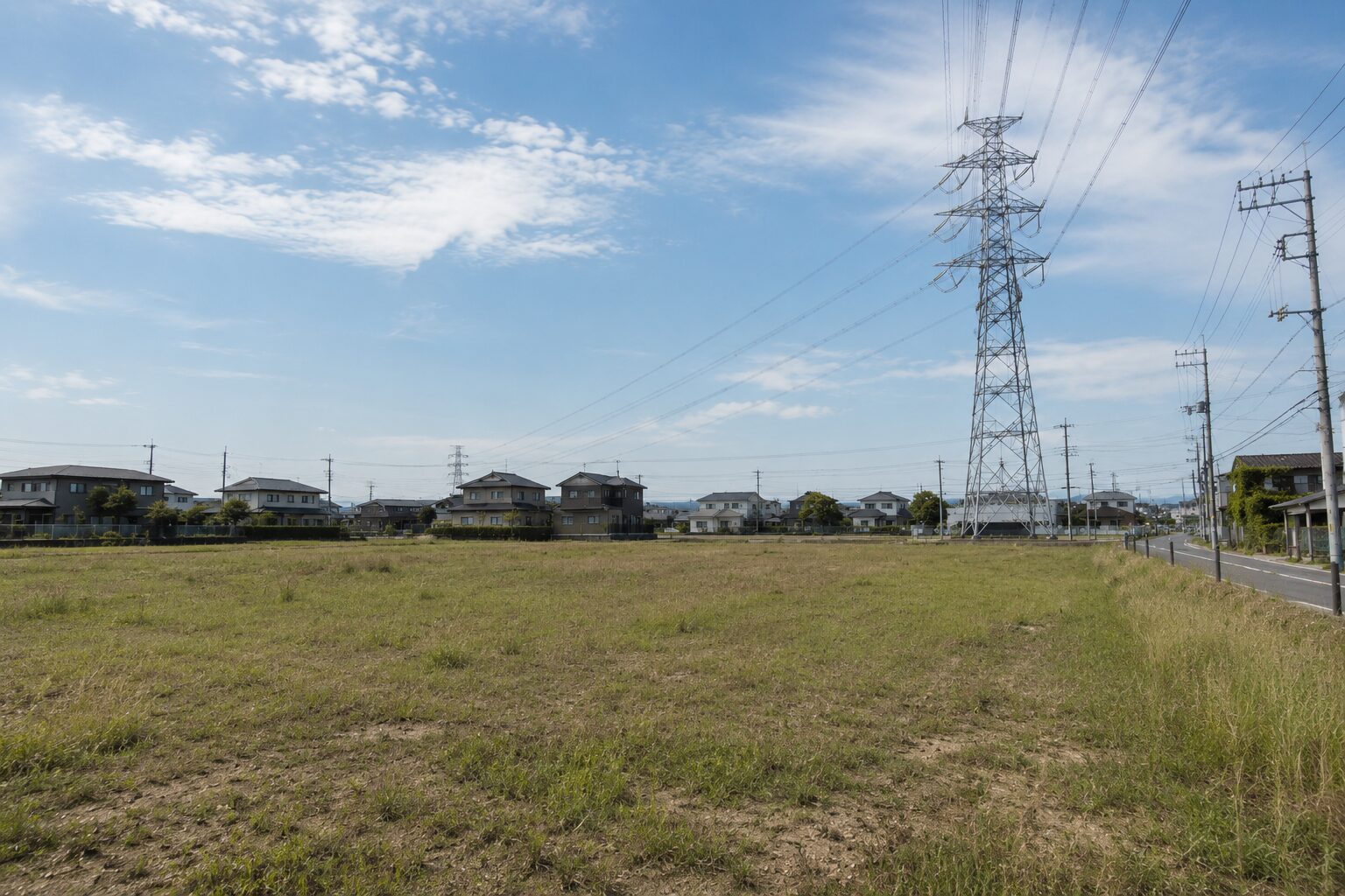 系統用蓄電池の設置に適した、送電線が近くにある平坦な遊休地の風景